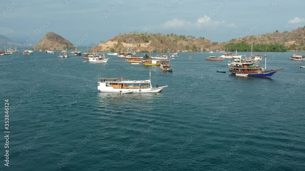 Aerial drone clip of boat port/harbor town, fishing boats and wooden jetty in calm ocean surrounded by small islands, Indonesia Aerial drone clip of boat port/harbor town, fishing boats and wooden jetty in calm ocean surrounded by small islands, Indonesia