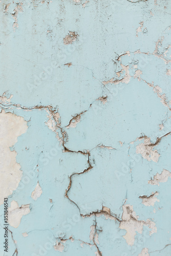 Texture of cracked wall with light blue paint, background or backdrop of abandoned building exterior. © elenaseiryk