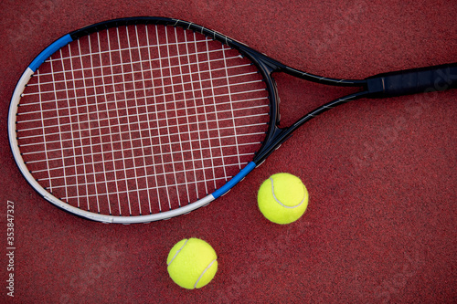 Tennis racket and balls on court. © ivanko80