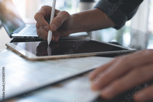 Fotografija Designer using stylus pen on digital tablet working on laptop computer