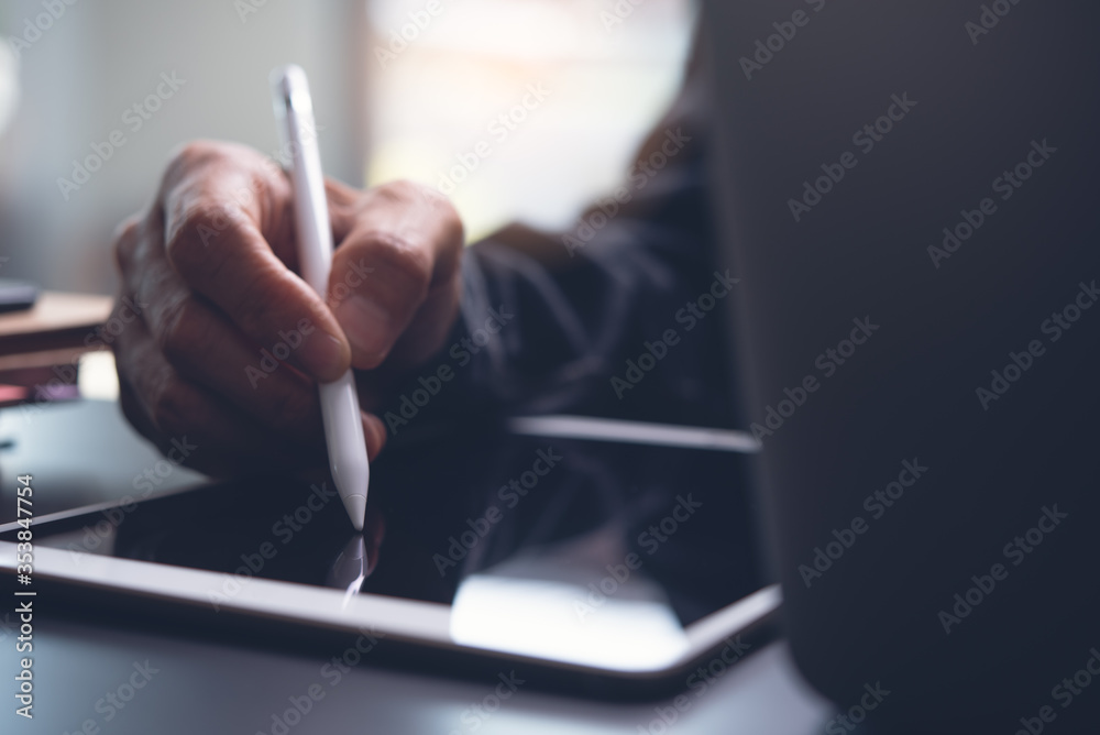 © tippapatt - Closeup of man hand using stylus pen touching on digital tablet screen