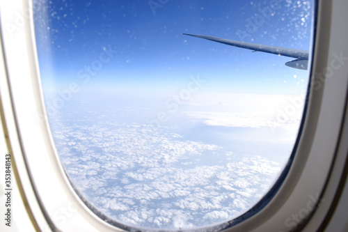 Looking Through window of airplane viewing of cloudscrape in blue sky