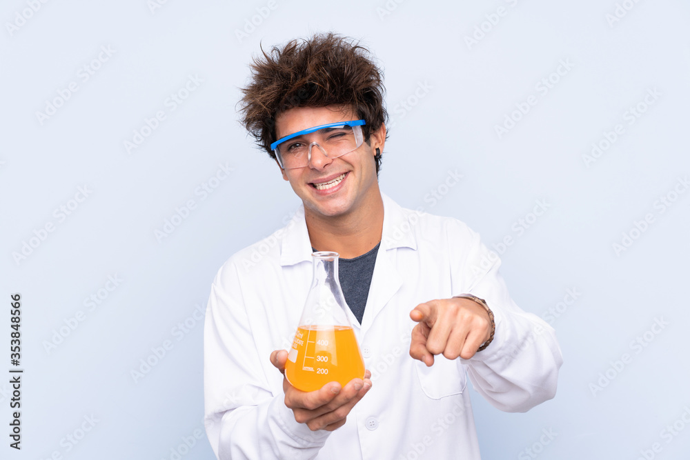 Young scientific man over isolated blue background points finger at you Young scientific man over isolated blue background points finger at you