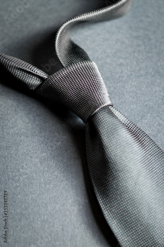 silver necktie on gray background closeup