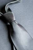 silver necktie on gray background closeup