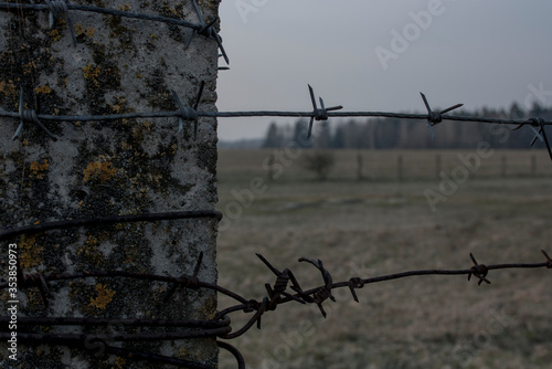 Old fence barbed wire fence under cloudy sky