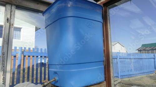 blue tank for watering vegetables in the greenhouse