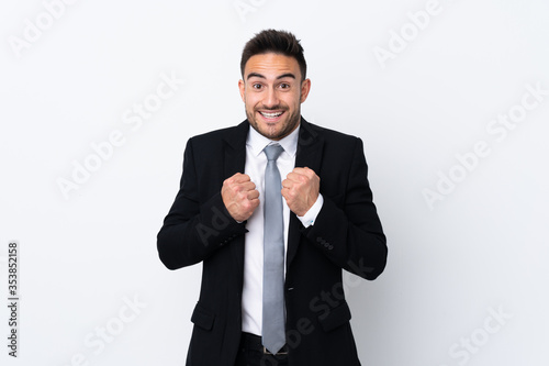 Young business man over isolated background celebrating a victory