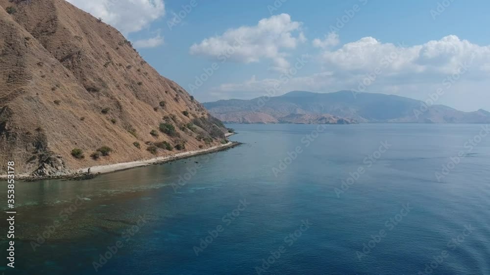 Aerial Drone, boats at a jetty in busy harbour, calm ocean, islands in background, Indonesia Aerial Drone, boats at a jetty in busy harbour, calm ocean, islands in background, Indonesia