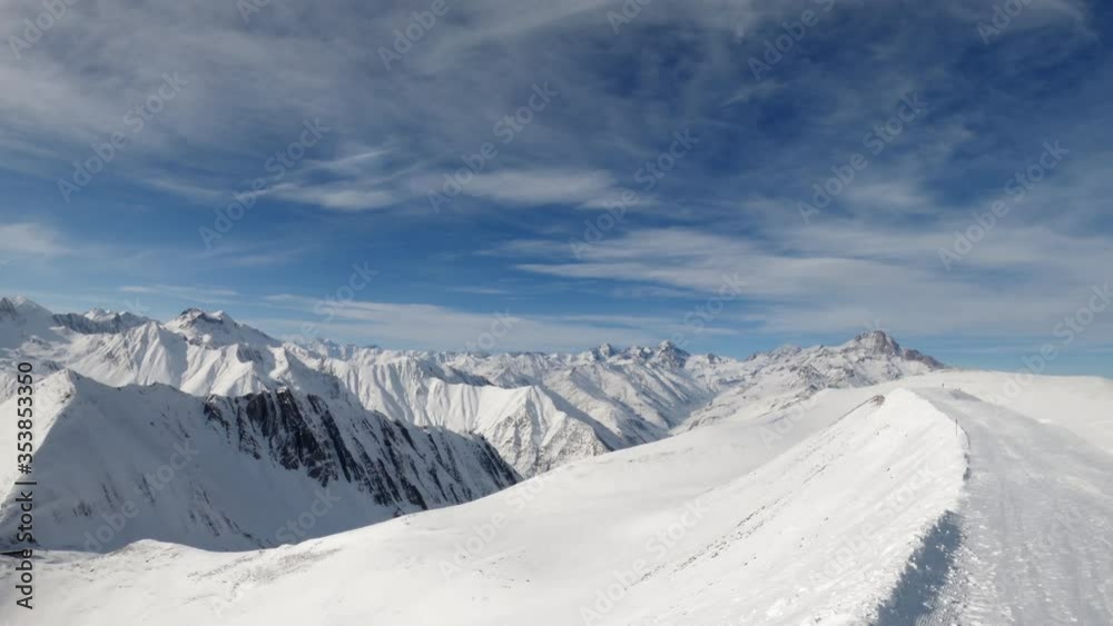 Spectacular aerial view of snow covered rugged and rough Caucasus mountain peaks on sunny day, pan right Spectacular aerial view of snow covered rugged and rough Caucasus mountain peaks on sunny day, pan right