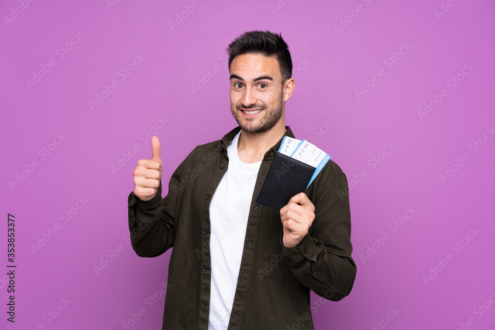 Young handsome man over isolated purple background in vacation holding a passport and plane with thumb up Young handsome man over isolated purple background in vacation holding a passport and plane with thumb up