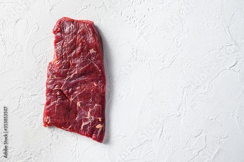 Raw skirt or flank steak,on a white stone background top view space for text.
