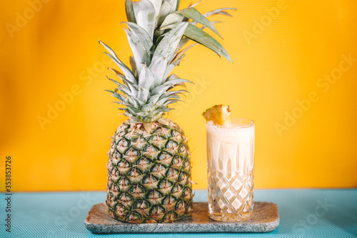 фотографія details of pina colada alcoholic cocktail with rum, pineapple and ice on yellow