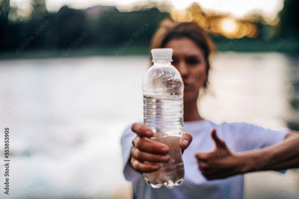 woman drinking water. Woman hand holding water. Nature background. woman drinking water. Woman hand holding water. Nature background.
