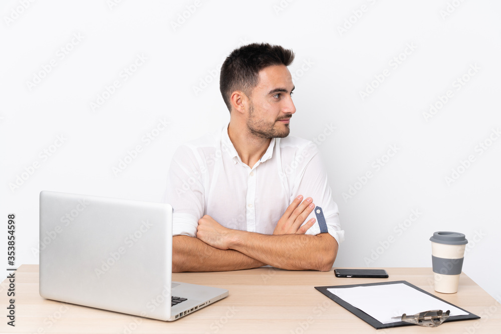Young business man with a mobile phone in a workplace looking to the side Young business man with a mobile phone in a workplace looking to the side