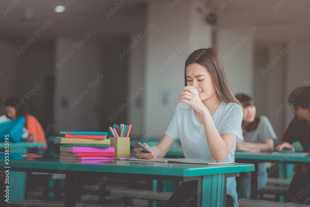 A young woman reading and writtening book with many books, happy education university concept. A young woman reading and writtening book with many books, happy education university concept.