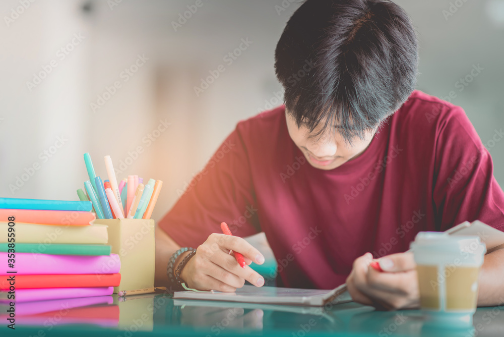 A young man reading and writtening book with many books, happy education university concept. A young man reading and writtening book with many books, happy education university concept.