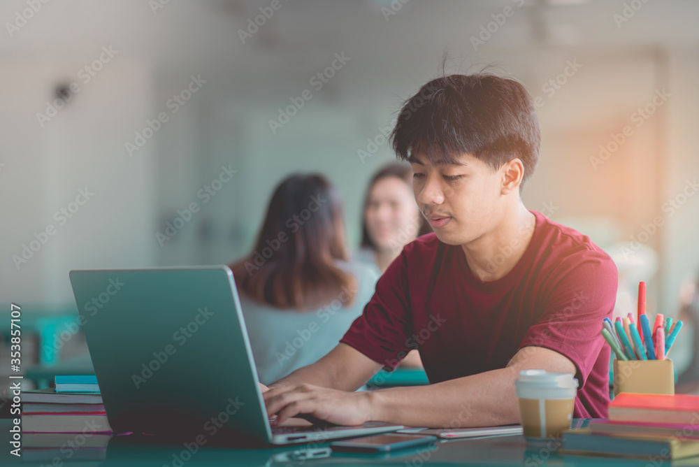 A young man reading and writtening book with many books, happy education university concept. A young man reading and writtening book with many books, happy education university concept.