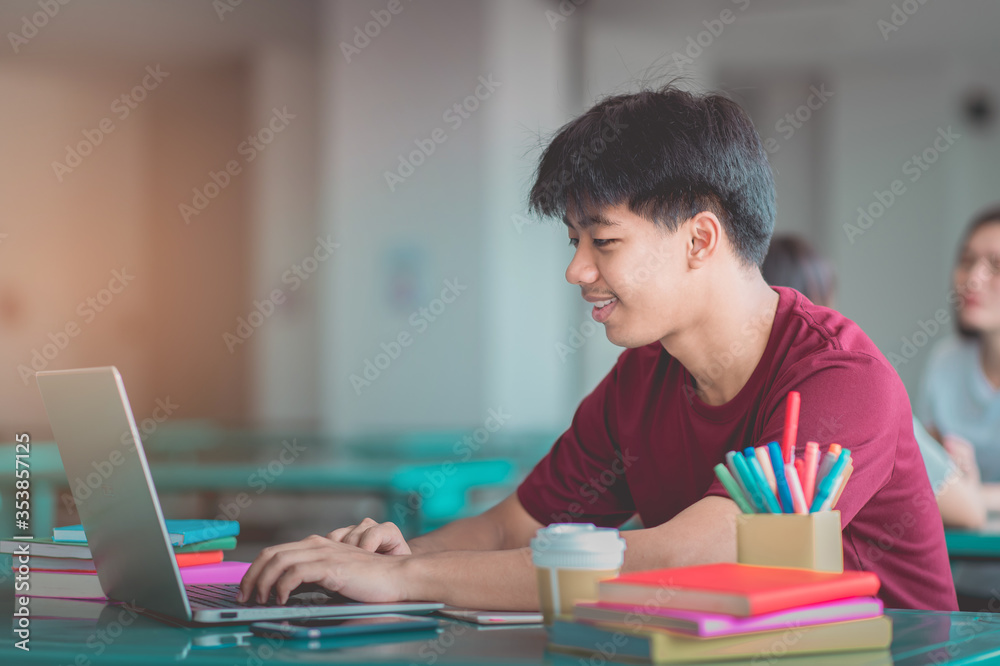 A young man reading and writtening book with many books, happy education university concept. A young man reading and writtening book with many books, happy education university concept.