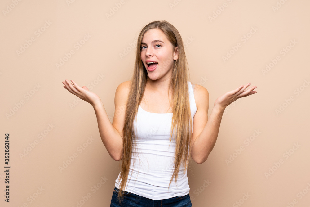 Teenager blonde girl over isolated background smiling a lot Teenager blonde girl over isolated background smiling a lot