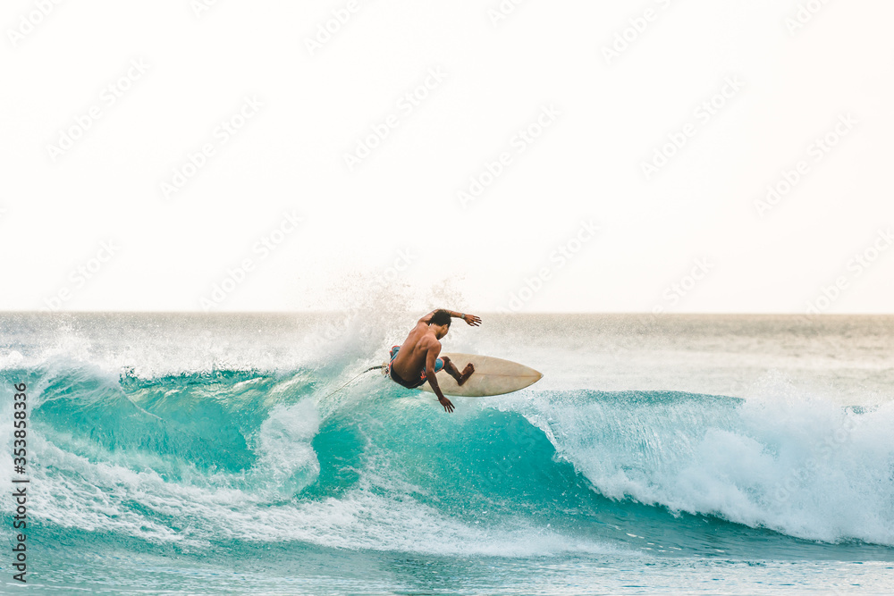 professional surfer riding waves in Bali, Indonesia. men catching waves in ocean, isolated. Surfing action water board sport. people water sport lessons and beach swimming activity on summer vacation - obrazy, fototapety, plakaty 