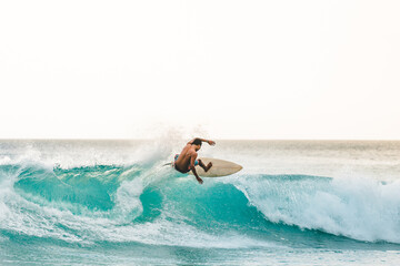 professional surfer riding waves in Bali, Indonesia. men catching waves in ocean, isolated. Surfing action water board sport. people water sport lessons and beach swimming activity on summer vacation