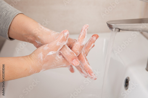 Proper hand washing as a prevention of coronavirus. Close-up of women's hands in soap in the bathroom