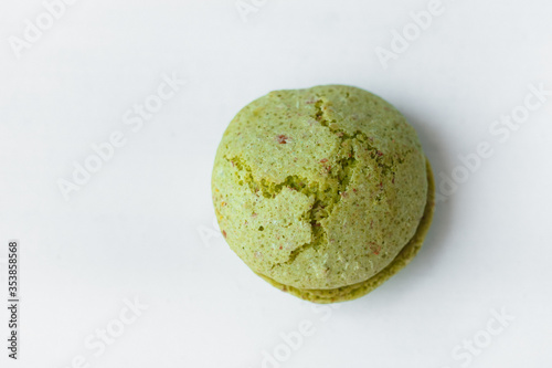 Green pistachios macaroon cookie isolated on white background. French gluten free dessert