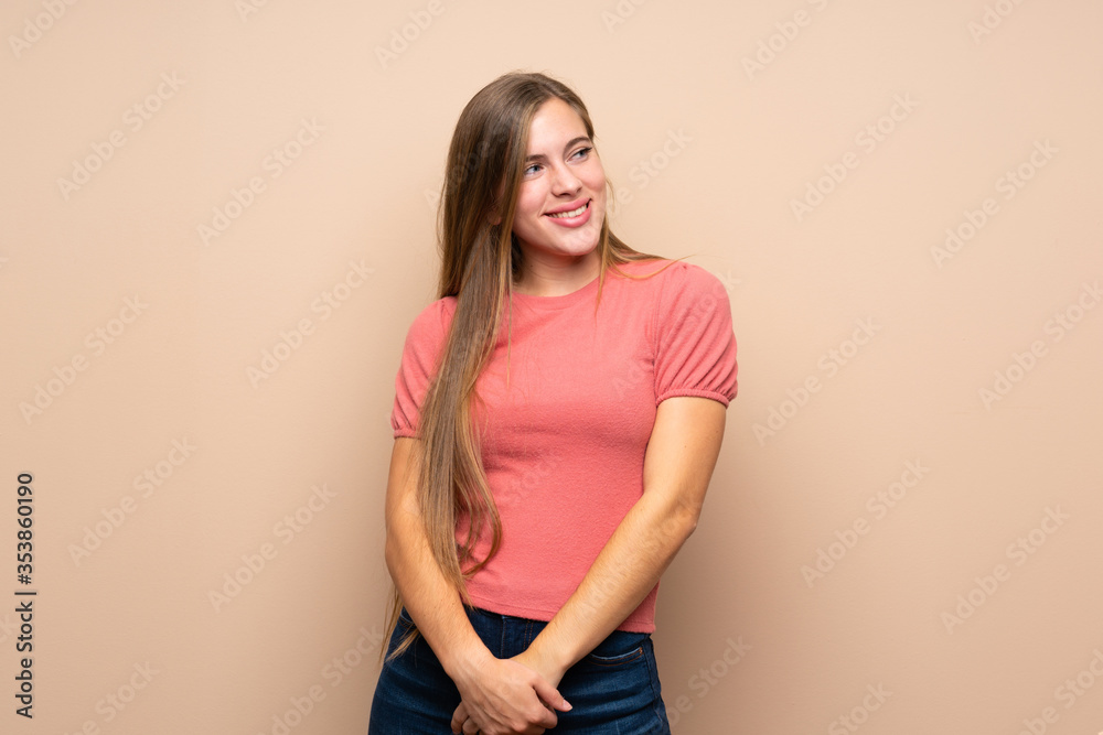 Teenager blonde girl over isolated background laughing and looking up Teenager blonde girl over isolated background laughing and looking up