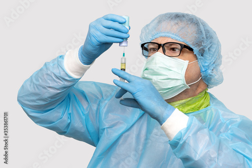 The doctor takes the medication from a bottle to an injection, on a white background. Scientist holding syringe and vaccine.