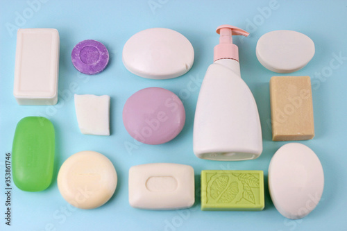 Hygiene and prevention of viral diseases concept.Various soap bar on blue background with blank bottle mock up.Set of soap different shape and color on baby blue backdrop. Top view photo