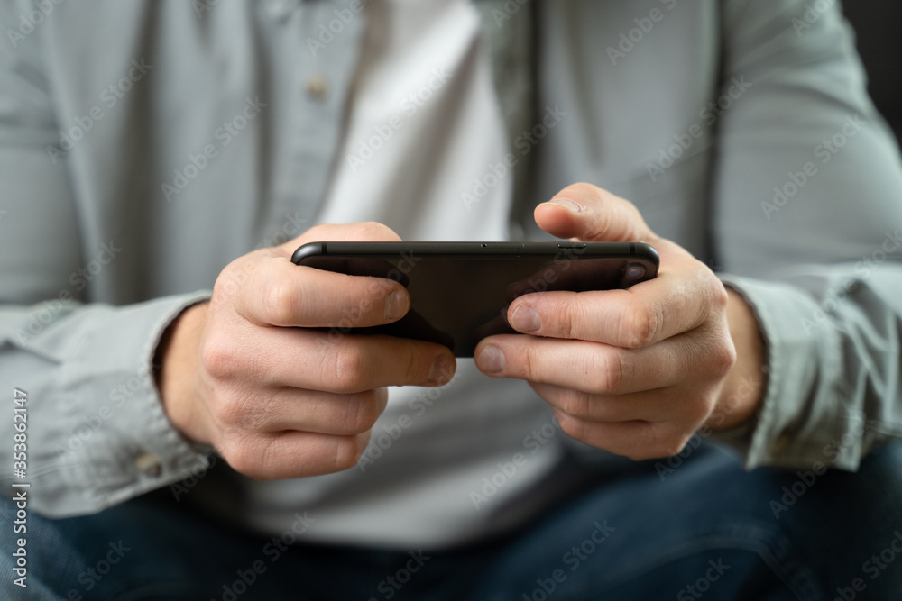 Happy, young man playing game on smartphone at home Happy, young man playing game on smartphone at home