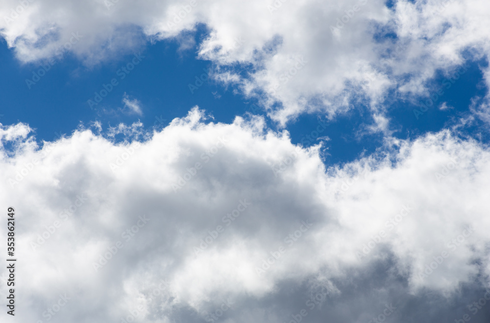Fototapeta premium Fluffy clouds cover the summer blue sky