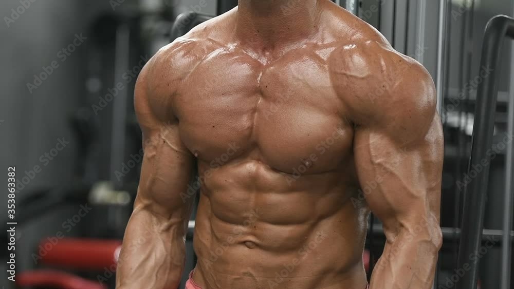 Bodybuilder handsome strong athletic rough man pumping up muscles biceps workout fitness and bodybuilding healthy concept background - muscular fitness men doing arms exercises in gym naked torso
