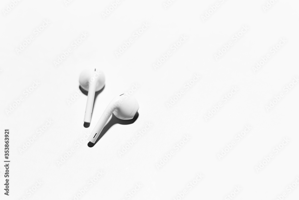 Close-up of white wireless earphones, isolated on background of white. Close-up of white wireless earphones, isolated on background of white.