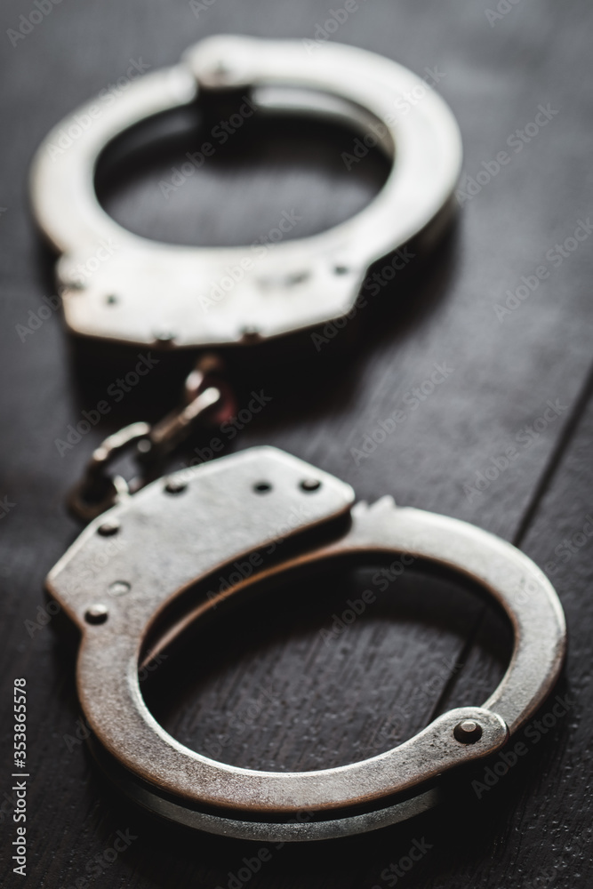 steel metal Handcuffs on brown background steel metal Handcuffs on brown background