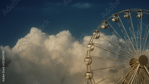ferris wheel against blue sky and clouds