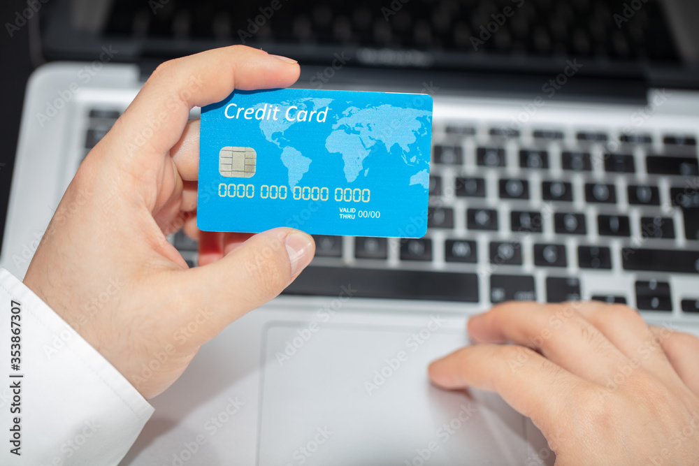 Close up of man with laptop computer and credit card at home. Close up of man with laptop computer and credit card at home.