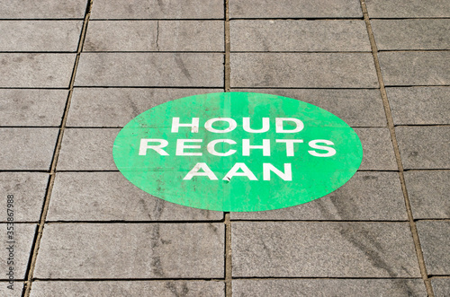 Rotterdam, The Netherlands, May 17, 2020: pavement tiles at Lijnbaan shopping street with large sticker calling for pepole to keep right to prevent spreading of covid-19