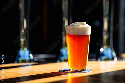 Glass of beer on wooden table photo