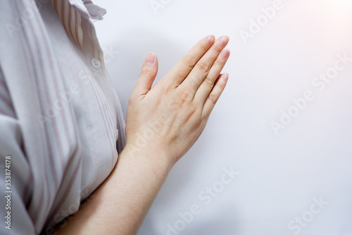 The cropped shot view of womans' hand 
pay respect with the natural white background. For hoping the situation will get better soon.