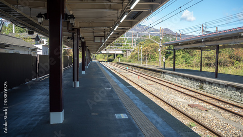 Empty platform at train station with metal sheet roof on clear blue sky background , copy space