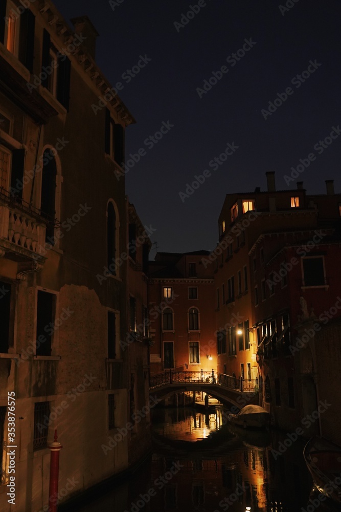 Bright single lamp lighten the alley river in Venice