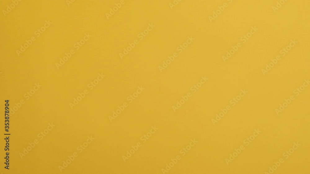 Chocolate corn cereal balls moving up and down on a yellow background.