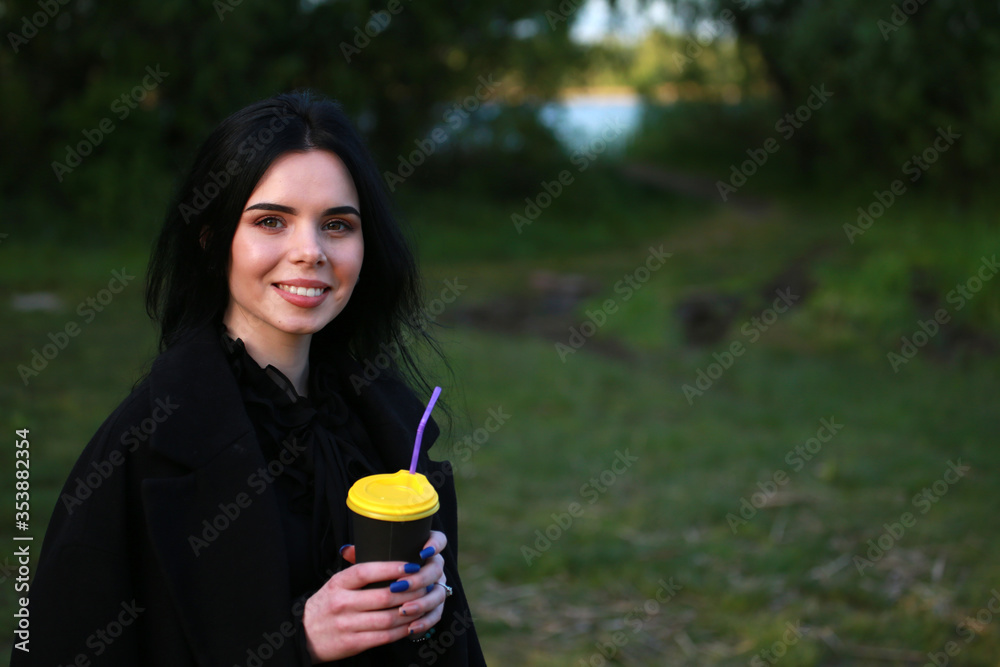 beautiful brunette girl with coffee on a background of nature beautiful brunette girl with coffee on a background of nature