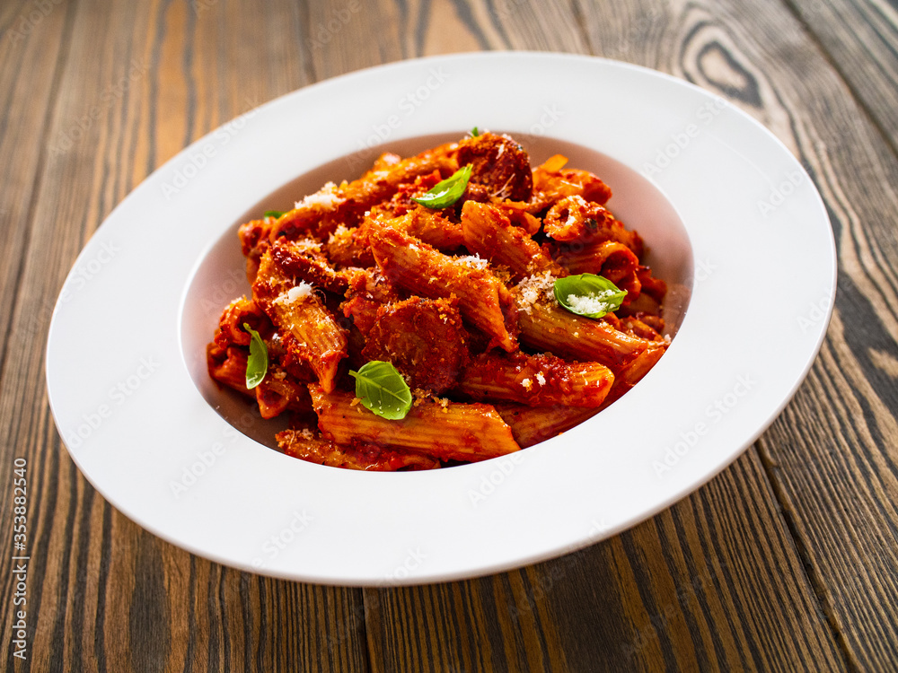 Penne with meat, tomato sauce and vegetables on white background
Penne with meat, tomato sauce and vegetables on white background