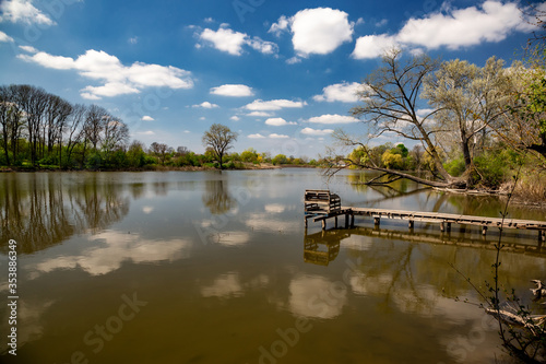 Beautiful river in the village on a sunny day with clouds. rest in the village © Sergii