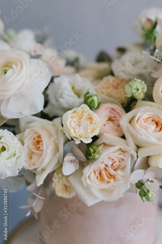 Beautiful bouquet of flowers in a box. A bouquet in peach tones. Stylish bouquet of peonies, ranunculis and roses. Flower shop concept. Floristics