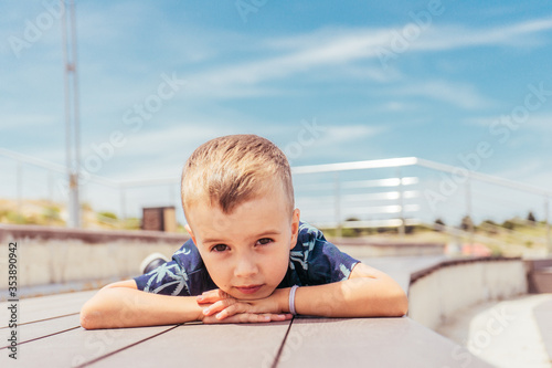 Boy in the summer against the sky in a beautiful T-shirt with palm trees