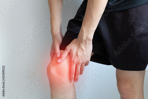 Knee pain after exercise concept. Man holds on his knee after knee injury. Inflammation or arthritis concept for graphic design and poster. photo